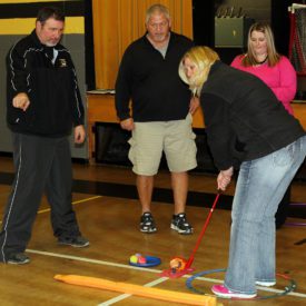 Susan Christian gets some chipping advice from Tom Kindle, left, as Mark Johnson and Amy Miller look on during the SNAG instruction session Feb. 18 at Sedalia Middle School. Christian said, "Even students who have never golfed before will succeed with this program because it has easy, step-by-step instructions and visual aids to help in the learning process.