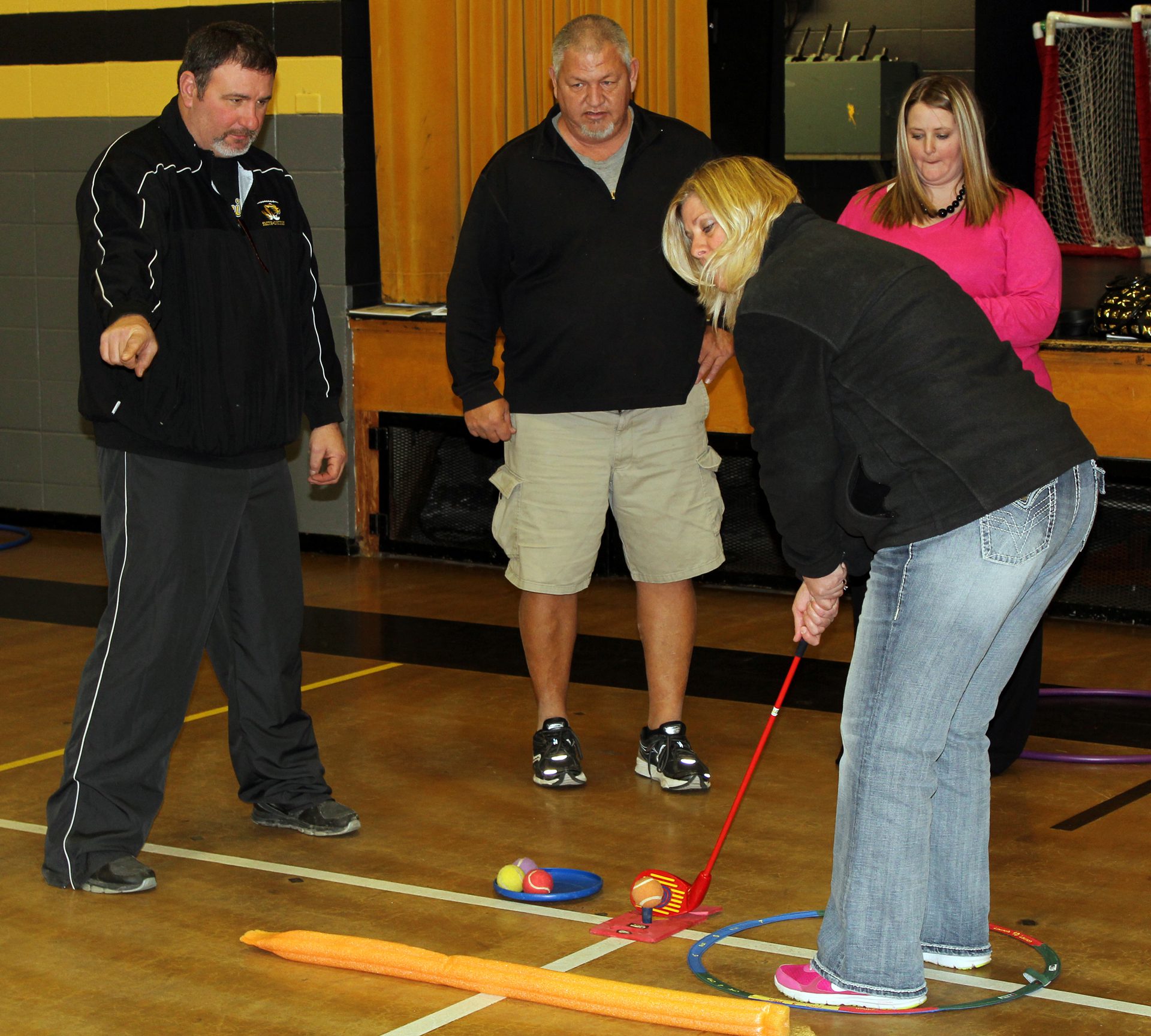 Susan Christian gets some chipping advice from Tom Kindle, left, as Mark Johnson and Amy Miller look on during the SNAG instruction session Feb. 18 at Sedalia Middle School. Christian said, "Even students who have never golfed before will succeed with this program because it has easy, step-by-step instructions and visual aids to help in the learning process.